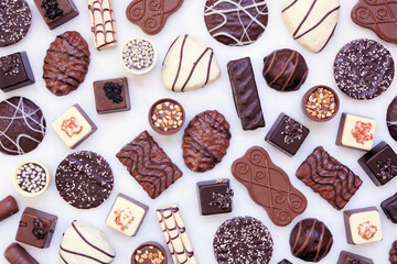 Poster - Chocolate background with an assortment of fine, luxurious sweets. Top view on a white marble background.