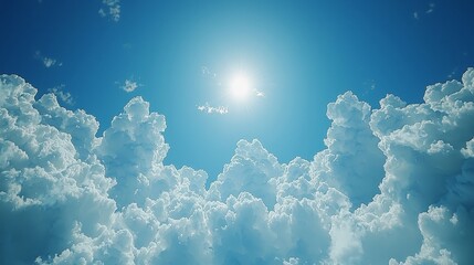 Wall Mural - Bright sunlight illuminating fluffy clouds in a clear blue sky.
