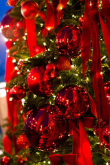 Wall Mural - christmas tree with red toy balls, lights bokeh in the background, merry christmas, shallow depth of