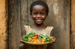 © Victoria - Smiling african girl holding plate with fresh vegetables