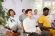 © JackF - Group of focused men attentively listens to a lecture on same-sex relationships, sitting on chairs in the audience
