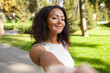© Andrii - Smiling woman with vitiligo pigmentation skin problem taking selfie in park. Portrait of African American lady spending leisure time outdoors during weekend