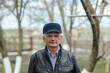 © sharshonm - One modern senior caucasian man portrait of male grandfather without a beard and hat cap stand in front of his house in day wear shirt happy confident copy space.