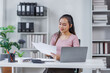 © David - Asian Businesswoman Using laptop computer and working at office with calculator document on desk, doing planning analyzing the financial report, business plan investment, finance analysis concept.