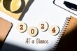 © Debalina - 2024 Year at a glance concept on wooden chips and inscription on desk background. 2024 highlights, performance evaluation, recap, review.