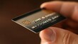 © Badass Prodigy - A close-up of a hand holding a credit card, emphasizing its design and details.