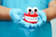 © manassanant - Funny red teeth with eye toy denture model for dental health care.