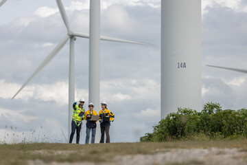Fototapete - Engineer wearing safety uniform using laptop discussed plan about renewable energy at station energy power wind turbine. technology protect environment reduce global warming problems.