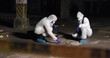 © peopleimages.com - Crime scene, team or forensics at night with swab, evidence or DNA sample clue in abandoned warehouse. CSI people, hazmat suit or investigation in spotlight for legal service, inspection or pathology