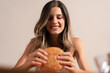 © Lomb - Young woman enjoying burger happy smile food pleasure lifestyle mindful eating balance wellness joy