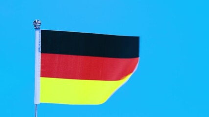 Wall Mural - German flag waving on blue background, slow motion