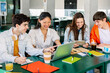 © Xavier Lorenzo - Diverse group of college students studying together at university cafeteria. Happy classmate friends talking while preparing exam or doing group work sitting on bar table outside. Education concept.