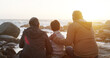 © peopleimages.com - Family, outdoor and rock by sea with child, sunrise and grandparents at morning in nature on holiday. Vacation, back and beach with idea, calm and thinking of young kid on stone by waves with travel
