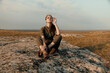 © SHOTPRIME STUDIO - Woman smoking a cigarette on top of a rock in the middle of a field as a part of nature trip