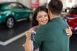 © Graphicroyalty - Happy beautiful loving couple buying new car in salon, standing over luxury automobile, hugging and showing key from their new auto, copy space