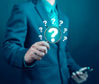 © WICHAI - Businessman showing question mark on laptop. Concept of asking, answering, business FAQ, thinking and wondering, brainstorming and problem solving.