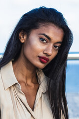 Beautiful indian businesswoman with long black hair and red lipstick posing for a portrait