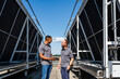 © Westend61 - Two employees with digital tablet talking on rooftop beside refrigeration installation