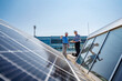 © Westend61 - Two businessmen wearing hardhats having a meeting on the roof of a company building with solar panels