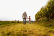 © Westend61 - Grandfather holding hands with granddaughter and walking near corn crops on field