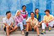 © Westend61 - Multi ethnic group of young people sitting on steps in front of wall