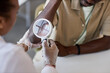© Seventyfour - Close up of female doctor as dermatologist examining patient in clinic and using magnifying glass copy space