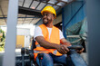 © dusanpetkovic1 - Cheerful black industry worker in working uniform driving forklift at industrial zone and looking away. © dusanpetkovic1 - Cheerful black industry worker in working uniform driving forklift at industrial zone and looking away.