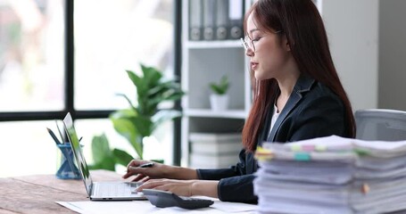 Wall Mural - Asian Business woman using calculator and laptop for doing math finance on an office desk, tax, report, accounting, statistics, and analytical research concept
