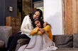 © Wavebreak Media - Comforting embrace on cozy sofa, two multiracial female friends sharing emotional support at home