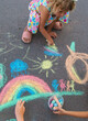 © yanadjan - Children draw with chalk on the asphalt. Selective focus.