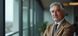 © Yury - Senior Businessman Confidently Looking Forward in Modern Office Against City View