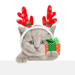 Aufkleber - Cute kitten dressed like santa claus reindeer  Rudolf holds gift box and looks blank white board. isolated on white background