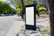© Nina Abrevaya - A blank billboard on the street in Buenos Aires, Argentina with jacaranda trees in the background during spring. Space for text for advertising signage ideas for mockup