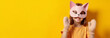 © Jim1786 - banner copy space portrait quadrober child girl in animal cat mask on solid yellow studio background, quadrobics furry terrians and carnival festive action.