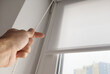 © Angelov - Photo of male hands using wand to close windows blinds