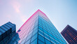 © imran - Low-angle view of a modern skyscraper with pink and blue hues. Contemporary urban architecture and business growth and modern concept.