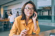 © BullRun - Female freelancer talking on phone at desk