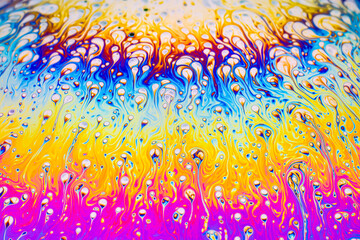 real photograph of a colorful light interference on a soap bubble surface with random swirls, curves