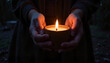 © Elenba - Hands holding a glowing candle, creating a serene atmosphere in dim lighting