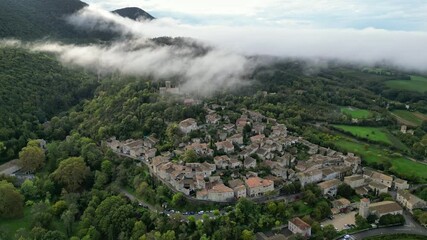 Wall Mural - Mirmande, France - 1 November 2024: Panoramic view of the prettiest small towns in France - Mirmande with morning fog. In the south of France in the Rhones Alpes - Drome area