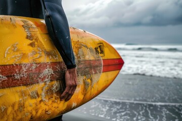 Wall Mural - A person holding a surfboard on a sunny beach, perfect for travel or adventure marketing