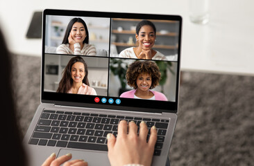 Poster - A group of four women smiles at each other during a virtual meeting on a laptop. The setting is bright and cozy, showing a modern workspace.