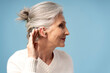 © Maria Vitkovska - Profile, portrait of beautiful smiling gray haired woman having hearing aid in ear looking away