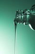 © Tatyana Lavrova/Stocksy - Water pouring from a clear glass bottle on gradient green background