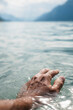 © Blue Collectors/Stocksy - A man's hand on the water of the lake.