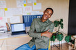 © BONNINSTUDIO/Stocksy - Young entrepreneur smiling with crossed arms in his office