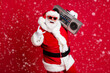 © deagreez - Full body size photo of retired old man grey beard hold boombox show horns make youngsters envious hard loud noise wear santa costume sunglass headwear x-mas isolated red color background