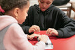 © Anya Brewley Schultheiss/Stocksy - Two young sisters working together to gift wrap an item.