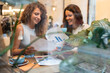 © Alvaro Lavin/Stocksy - Two businesswomen having meeting analyzing financial charts in cafe