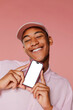 © BONNINSTUDIO/Stocksy - Cheerful man showing smartphone with mockup screen on pink background